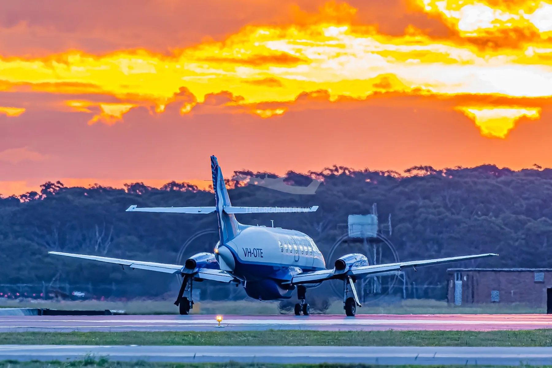 FlyPelican aircraft taxiing beneath a sunset